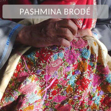 Mains d’un artisan brodant un pashmina en cachemire avec des motifs color�s